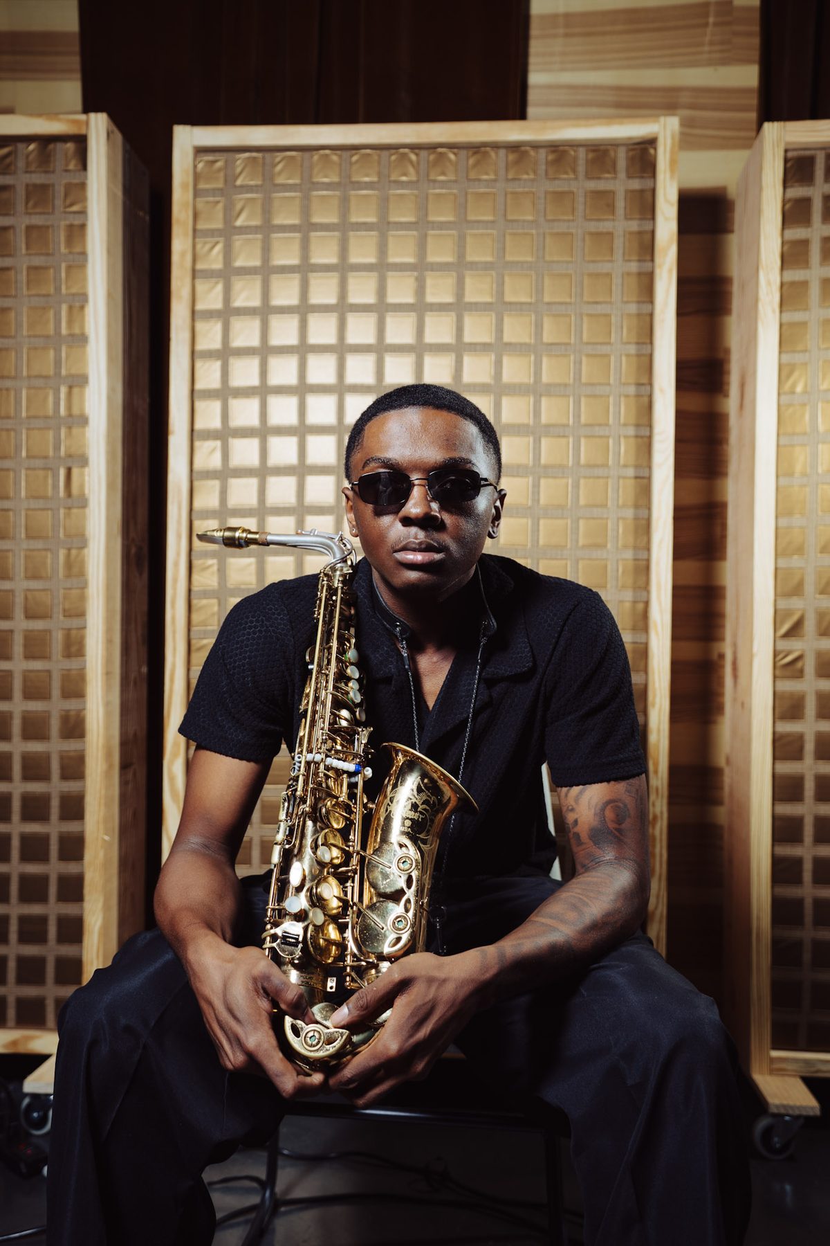 Ry Lo seated with alto saxophone in the studio